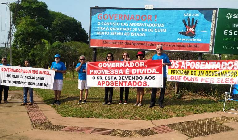 Movimento dos Aposentados de MS instala outodoor na entrada do Parque dos Poderes e faz ato contra o desconto de 14%